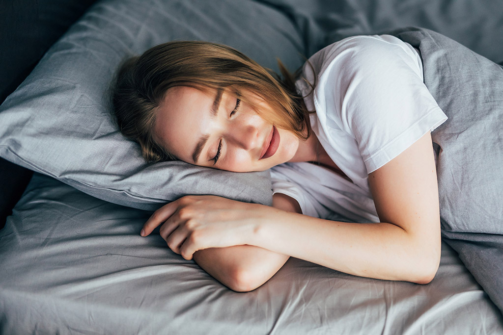 beautiful young smiling woman sleeping in bed